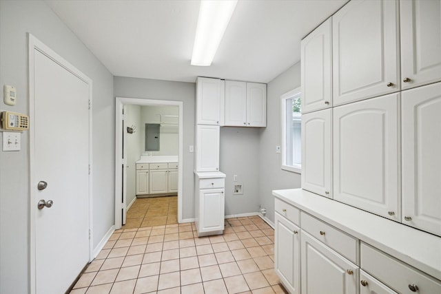 14303 Bonney Brier Dr, Houston, TX 77069 - kitchen with white cabinetry, electric panel, light countertops, light tile patterned floors, and baseboards