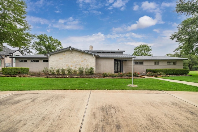 14303 Bonney Brier Dr, Houston, TX 77069 - mid-century modern home with a chimney, a front yard, stone siding, and metal roof
