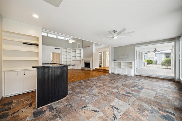 14303 Bonney Brier Dr, Houston, TX 77069 - kitchen featuring ceiling fan, stone tile flooring, built in features, dark countertops, and open floor plan
