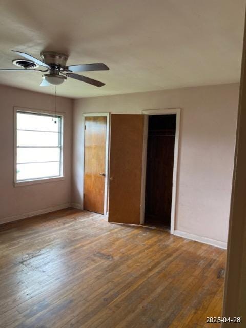 1912 18th St, Huntsville, TX 77340 - unfurnished bedroom with baseboards, wood finished floors, multiple closets, and ceiling fan