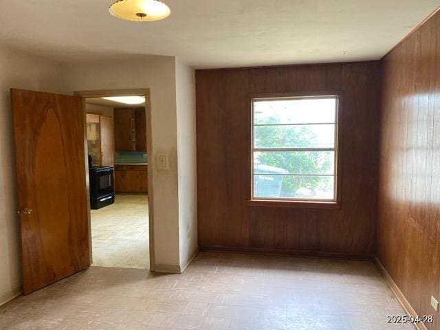 1912 18th St, Huntsville, TX 77340 - unfurnished room featuring wood walls, light flooring, and baseboards
