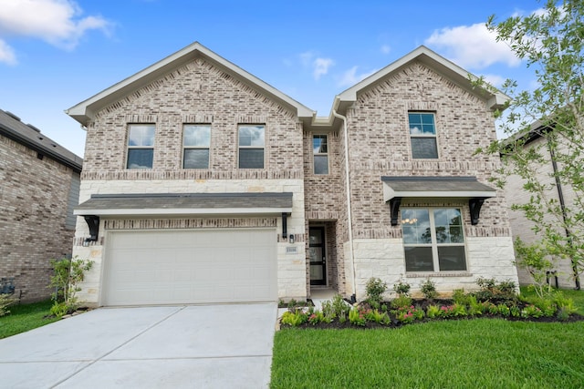 15198 Prairie Mill Dr, New Caney, TX 77357 - view of front of home with concrete driveway, an attached garage, a front yard, brick siding, and stone siding