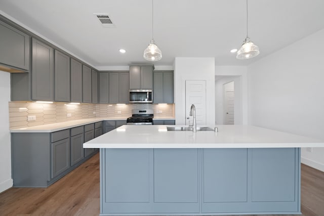 15198 Prairie Mill Dr, New Caney, TX 77357 - kitchen with stainless steel appliances, tasteful backsplash, light wood-style floors, pendant lighting, and recessed lighting