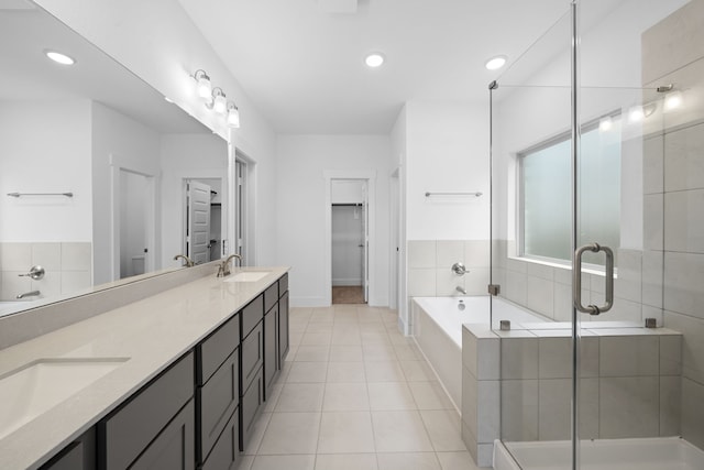 15198 Prairie Mill Dr, New Caney, TX 77357 - full bathroom featuring double vanity, a bath, a shower stall, tile patterned flooring, and recessed lighting