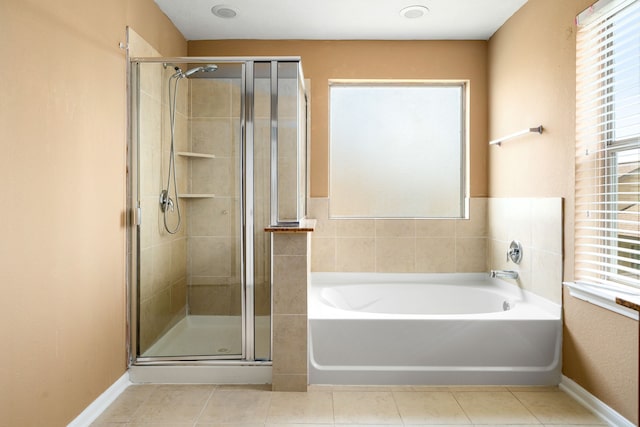 full bathroom featuring a shower stall, tile patterned flooring, a garden tub, and baseboards
