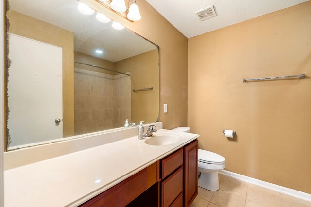 full bathroom with tile patterned floors, toilet, vanity, a shower, and baseboards