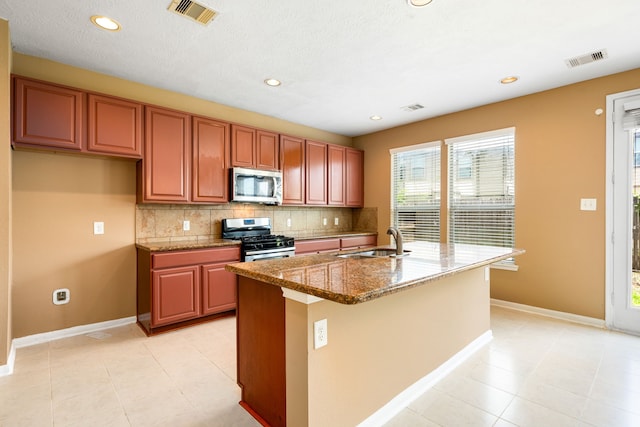 kitchen featuring stainless steel appliances, a sink, decorative backsplash, baseboards, and recessed lighting