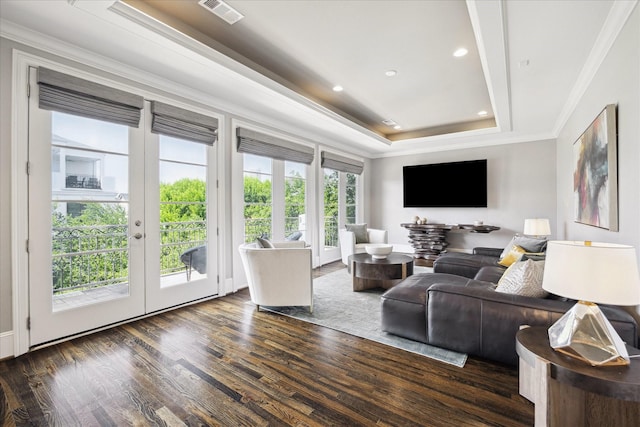 living area featuring a tray ceiling, crown molding, dark wood finished floors, french doors, and recessed lighting