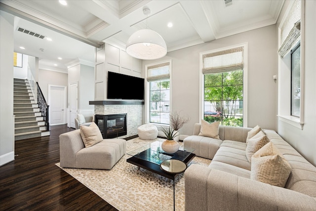 living area with a fireplace, dark wood-type flooring, crown molding, stairs, and beam ceiling