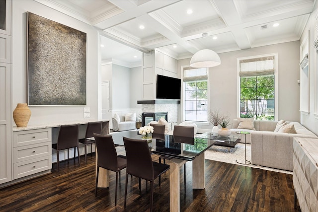 dining area with dark wood-style flooring, beam ceiling, coffered ceiling, a glass covered fireplace, and recessed lighting