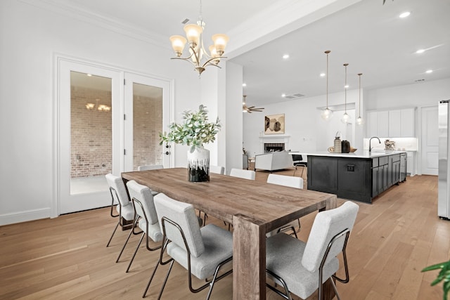 5357 Cherry Spring Dr, Spring, TX 77386 - dining room featuring a fireplace, light wood finished floors, a chandelier, recessed lighting, and ceiling fan