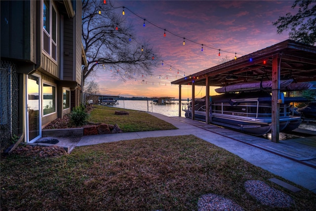 162 Ferncrest, Livingston, TX 77351 - view of grassy yard with boat lift, a water view, a dock, and a carport