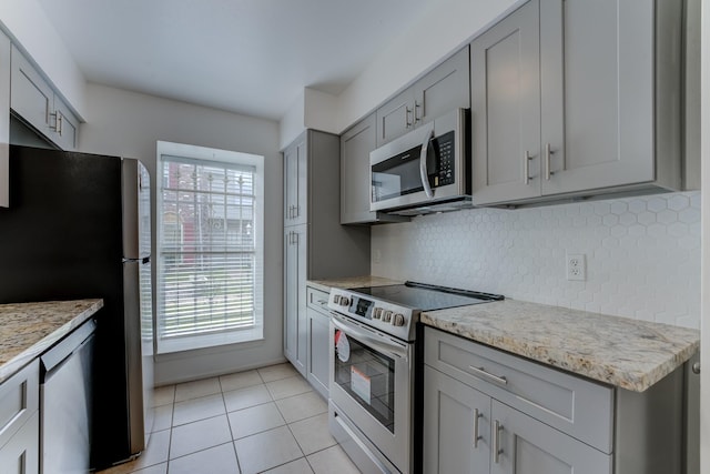 7938 Leonora St Unit B19, Houston, TX 77061 - kitchen featuring appliances with stainless steel finishes, gray cabinets, healthy amount of natural light, and tasteful backsplash