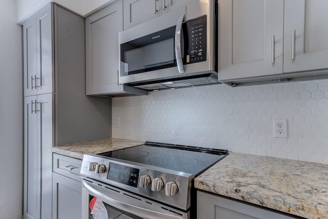 7938 Leonora St Unit B19, Houston, TX 77061 - kitchen featuring appliances with stainless steel finishes, gray cabinets, tasteful backsplash, and light stone countertops