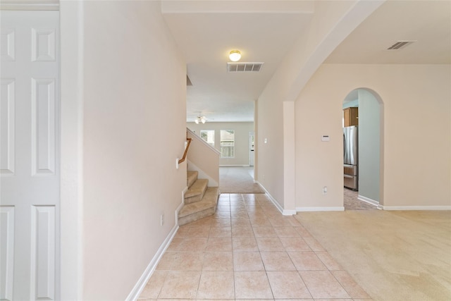 21514 Skyla Cir, Humble, TX 77338 - hall featuring arched walkways, light colored carpet, stairway, light tile patterned floors, and baseboards