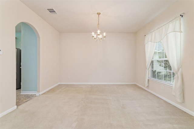 21514 Skyla Cir, Humble, TX 77338 - spare room featuring light colored carpet, arched walkways, a chandelier, and baseboards