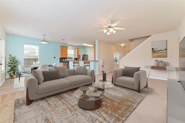 21514 Skyla Cir, Humble, TX 77338 - living area with light carpet, baseboards, ceiling fan, and stairway