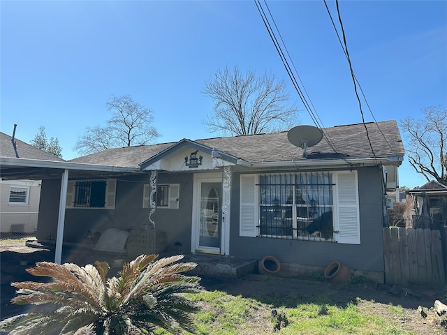 view of front of property with fence and roof with shingles