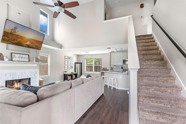 18406 Bristol Bay Ct, Humble, TX 77346 - living area featuring a high ceiling, dark wood finished floors, ceiling fan, stairway, and a fireplace