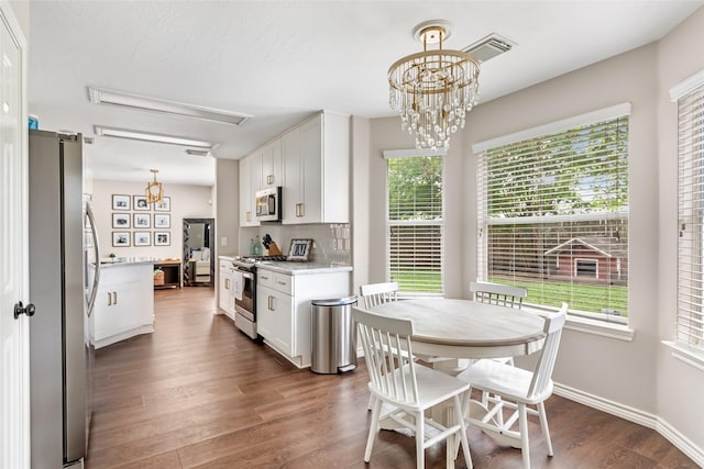 18406 Bristol Bay Ct, Humble, TX 77346 - kitchen featuring stainless steel appliances, light countertops, white cabinetry, dark wood-style flooring, and decorative light fixtures