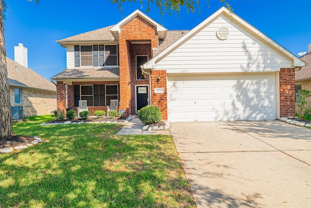 traditional-style house with brick siding, an attached garage, a front lawn, concrete driveway, and central AC unit