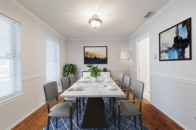 dining area with wood finished floors, ornamental molding, and baseboards