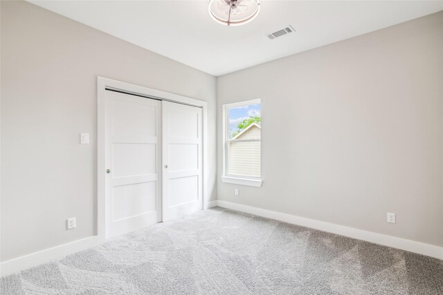 unfurnished bedroom with carpet floors, baseboards, and a closet