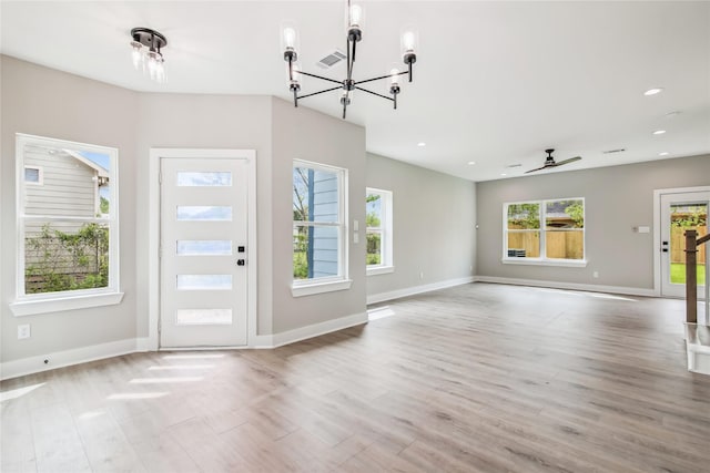 foyer featuring a chandelier, plenty of natural light, wood finished floors, baseboards, and recessed lighting