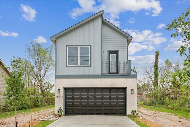 view of front facade with brick siding, board and batten siding, concrete driveway, and fence