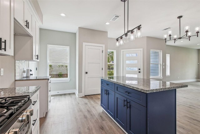 kitchen featuring blue cabinets, light wood finished floors, baseboards, white cabinetry, and recessed lighting