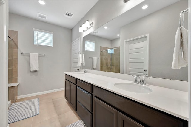 bathroom with a shower stall, double vanity, tile patterned flooring, recessed lighting, and baseboards