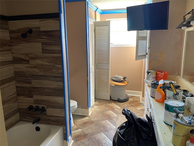 2138 Clifford St, Alvin, TX 77511 - bathroom featuring toilet, baseboards, stone finish floors, and tub / shower combination