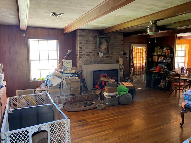 2138 Clifford St, Alvin, TX 77511 - living room with beamed ceiling, hardwood / wood-style floors, wood walls, a brick fireplace, and healthy amount of natural light