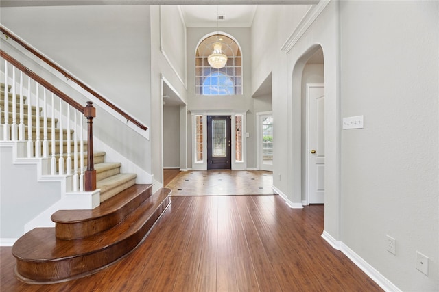 17406 Lonesome Dove Trl, Houston, TX 77095 - entryway with arched walkways, dark wood-type flooring, stairway, baseboards, and a towering ceiling