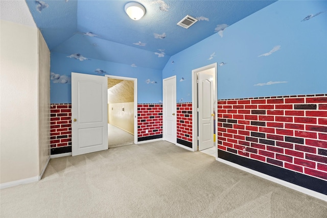 17406 Lonesome Dove Trl, Houston, TX 77095 - unfurnished bedroom with vaulted ceiling, carpet floors, wainscoting, and a textured ceiling