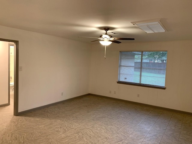 unfurnished room featuring ceiling fan and baseboards