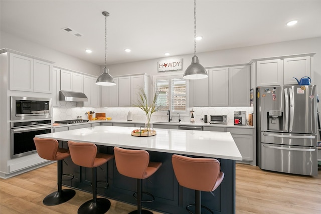 29622 Cedar Elm Way, Tomball, TX 77375 - kitchen with stainless steel appliances, decorative backsplash, recessed lighting, light countertops, and light wood finished floors