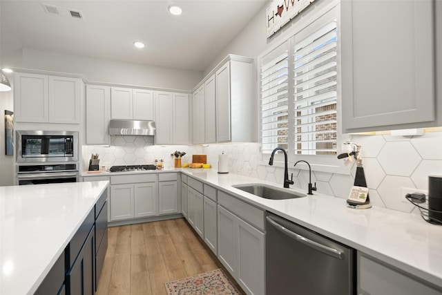 29622 Cedar Elm Way, Tomball, TX 77375 - kitchen with appliances with stainless steel finishes, a sink, under cabinet range hood, light countertops, and decorative backsplash