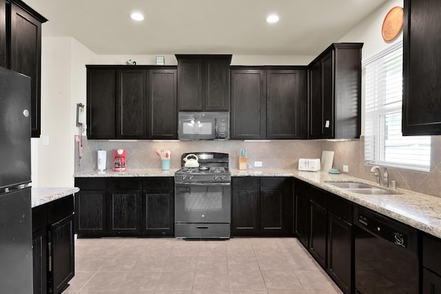 kitchen with black appliances, a sink, decorative backsplash, light stone counters, and light tile patterned flooring