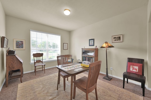 carpeted dining space featuring baseboards and an office area