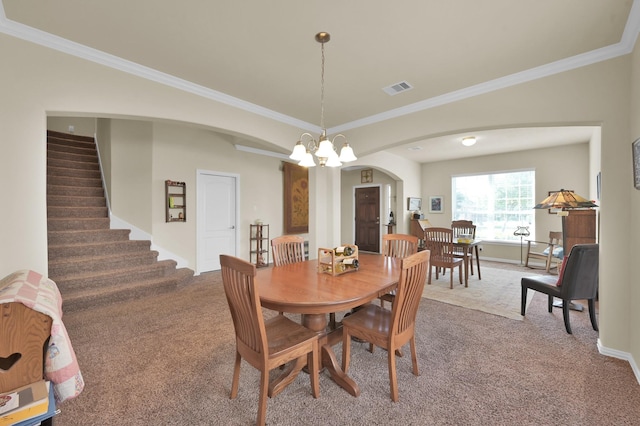 carpeted dining room with arched walkways, a chandelier, stairs, crown molding, and baseboards