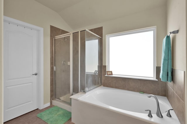 bathroom with a stall shower, tile patterned flooring, a bath, and vaulted ceiling