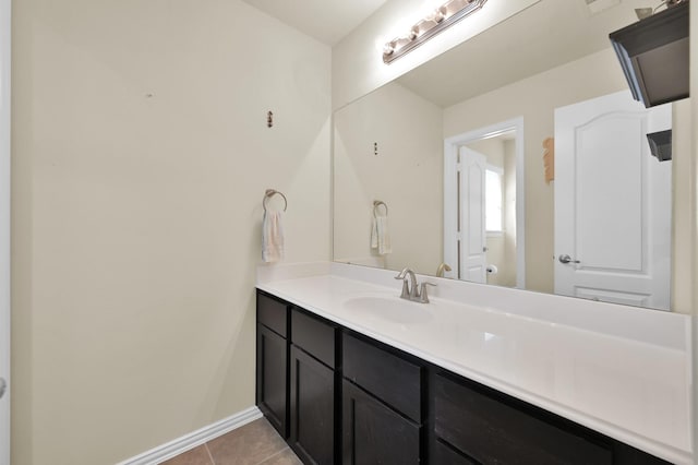 bathroom with vanity, tile patterned flooring, and baseboards
