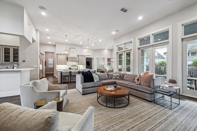 living room with dark wood-type flooring and recessed lighting