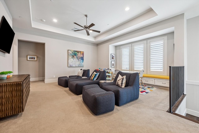 living area with light colored carpet, a ceiling fan, a raised ceiling, and recessed lighting