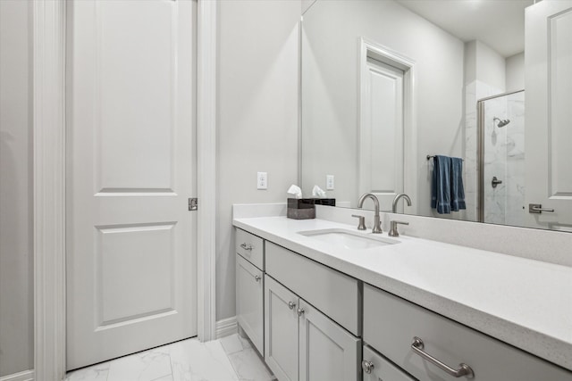 full bath featuring marble finish floors, a stall shower, vanity, and baseboards