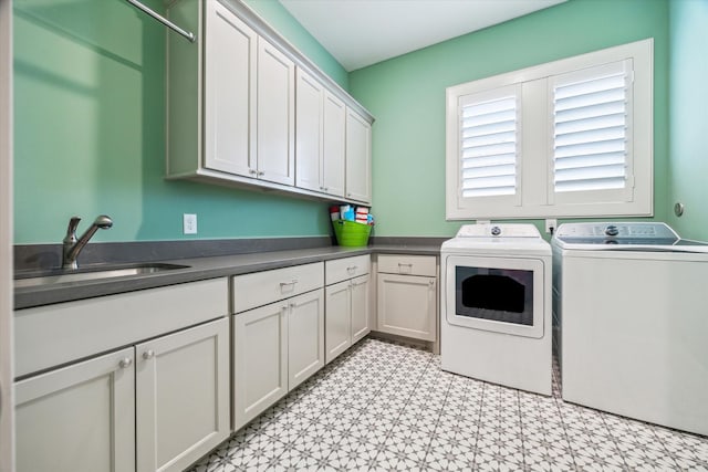 washroom with washer and dryer, cabinet space, and light flooring