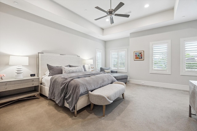 bedroom featuring light carpet, baseboards, recessed lighting, ceiling fan, and a tray ceiling