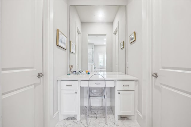 bathroom with marble look tiles, baseboards, and vanity