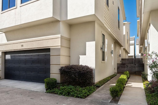 94 N Hutcheson St, Houston, TX 77003 - view of property exterior featuring an attached garage and stucco siding